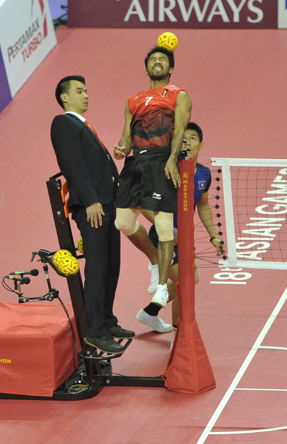 Pemain sepak takraw Indonesia, Rijal S (kanan) menyundul bola ke arah pemain Laos, pada pertandingan penyisihan quadrant putra sepak takraw, Asian Games 2018 di GOR Ranau, Jakabaring Sport City (JSC), Palembang, Sumatera Selatan,