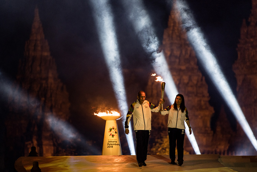 Legenda bulu tangkis Indonesia Susi Susanti (kanan) dan mantan atlet tenis nasional Yustedjo Tarik (kiri) membawa api obor dari India dan Mrapen yang telah dipersatukan saat Asian Games 2018 Torch Relay Concert di Kompleks Candi Prambanan, Sleman, DI Yogy