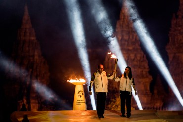 Legenda bulu tangkis Indonesia Susi Susanti (kanan) dan mantan atlet tenis nasional Yustedjo Tarik (kiri) membawa api obor dari India dan Mrapen yang telah dipersatukan saat Asian Games 2018 Torch Relay Concert di Kompleks Candi Prambanan, Sleman, DI Yogy