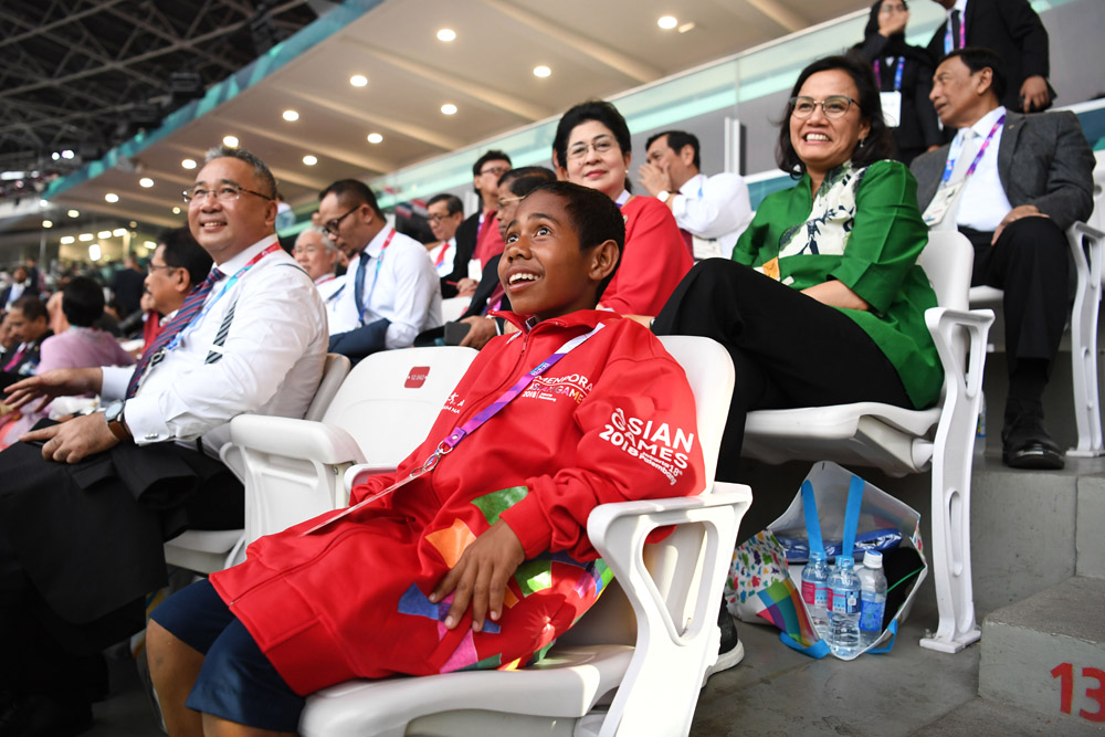 Yohanis Gama Marshall Lau alias Joni (tengah), siswa SMPN Silawan, Belu, Nusa Tenggara Timur duduk di antara menteri Kabinet Kerja saat menghadiri Upacara Pembukaan Asian Games ke-18 Tahun 2018 di Stadion Utama GBK, Senayan, Jakarta, Sabtu (18/8)
