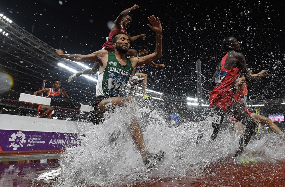 Sejumlah pelari melewati rintangan air saat final nomor Lari Halang Rintang 3.000M Putra Asian Games ke-18 Tahun 2018 di Stadion Utama Gelora Bung Karno Senayan, Jakarta, Senin (27/8).